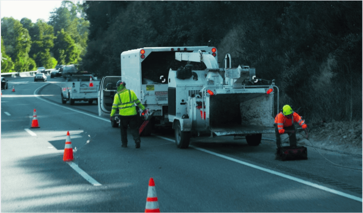 Trabajador vial colocando conos de seguridad para desviar el tráfico