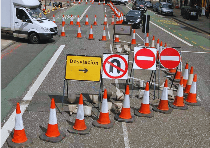 Conos de tráfico naranjas señalizando y delimitando un carril en obras viales